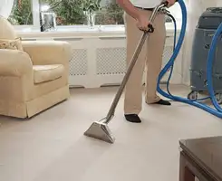 Carpet cleaning professional removing dirt and stains with a hot-water extraction tool in a home, Little Rock, AR.