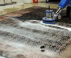 Professional rug cleaning with a rotary floor machine and shampoo foam, deep-cleaning an area rug, in Little Rock, AR.